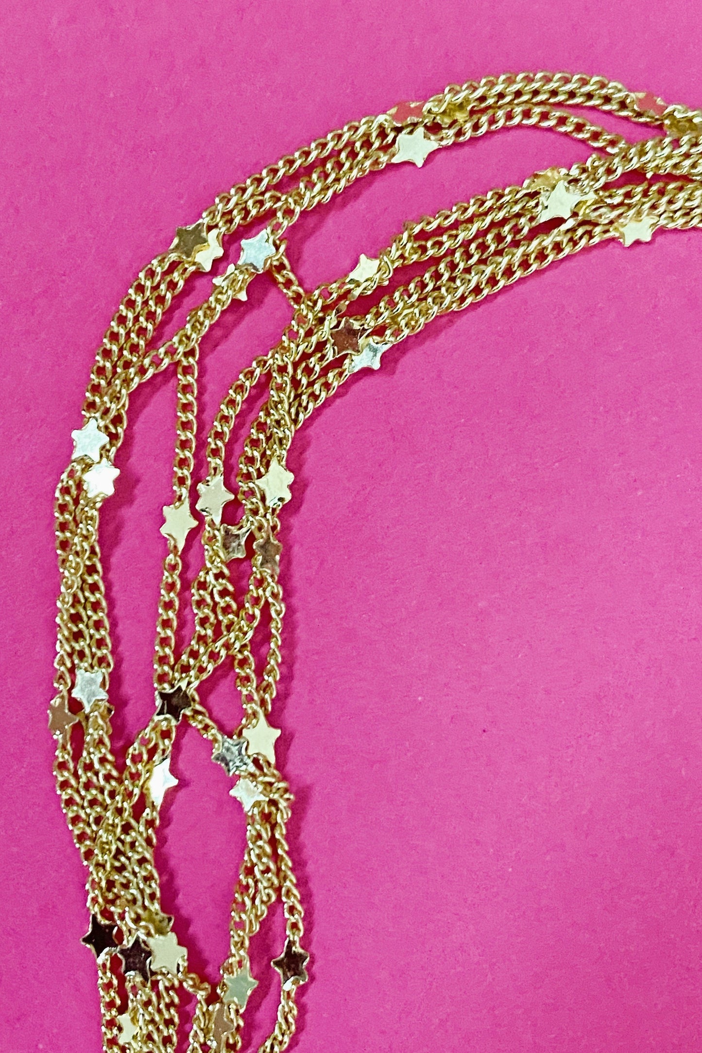 close up gold chain necklace with tiny star charms
