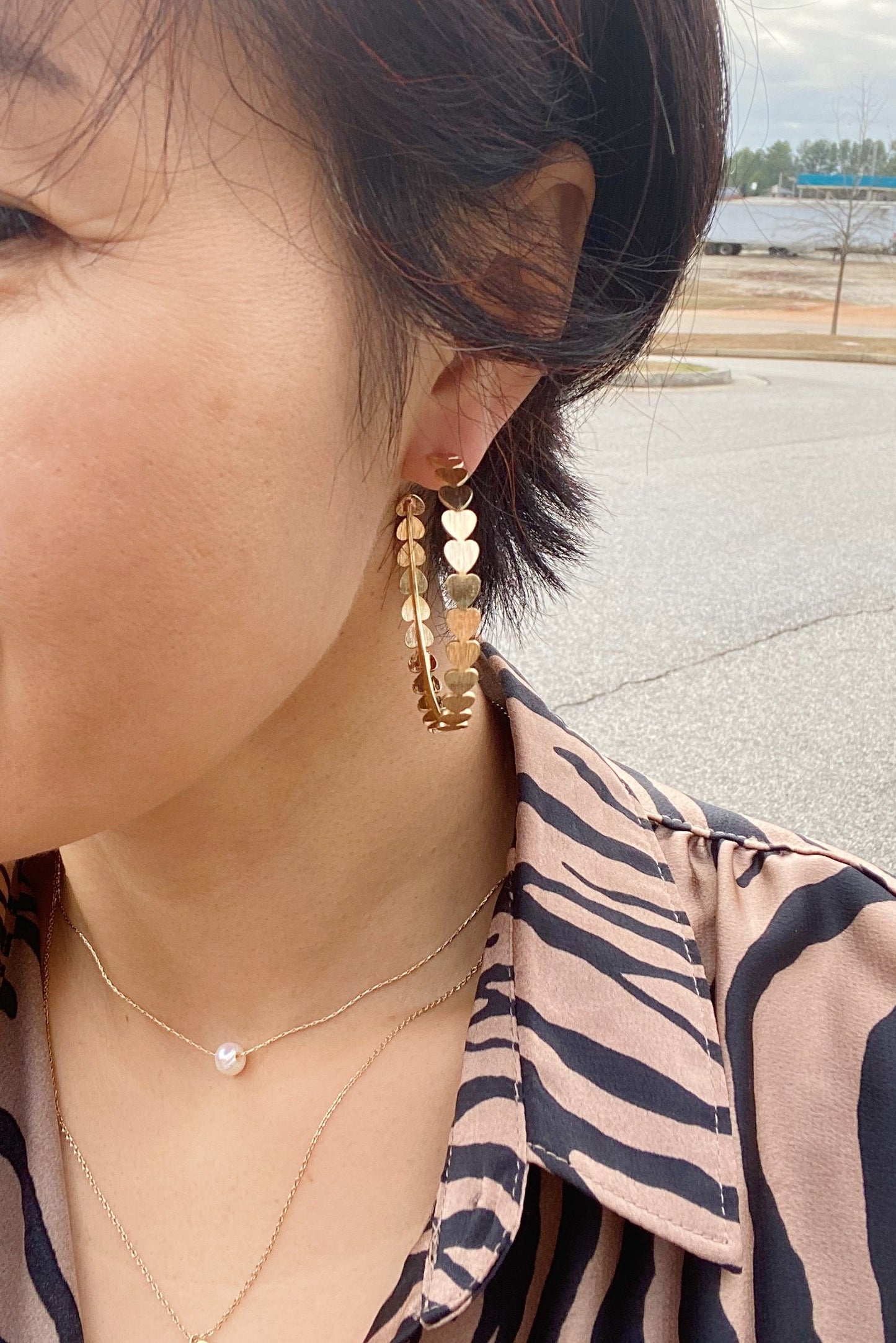 woman wearing gold hoop earrings with hearts all round