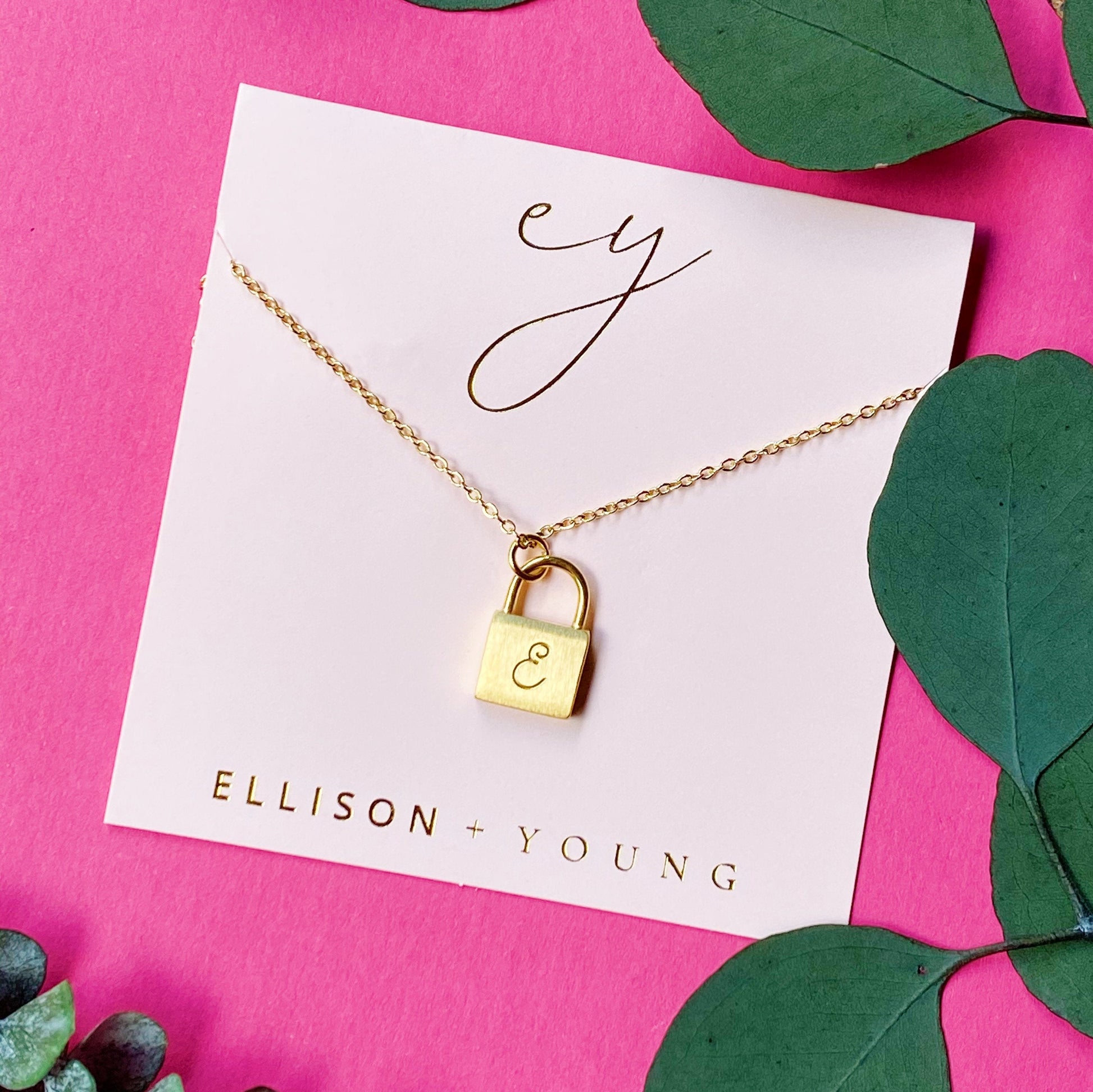 A 'E' initial necklace shown 